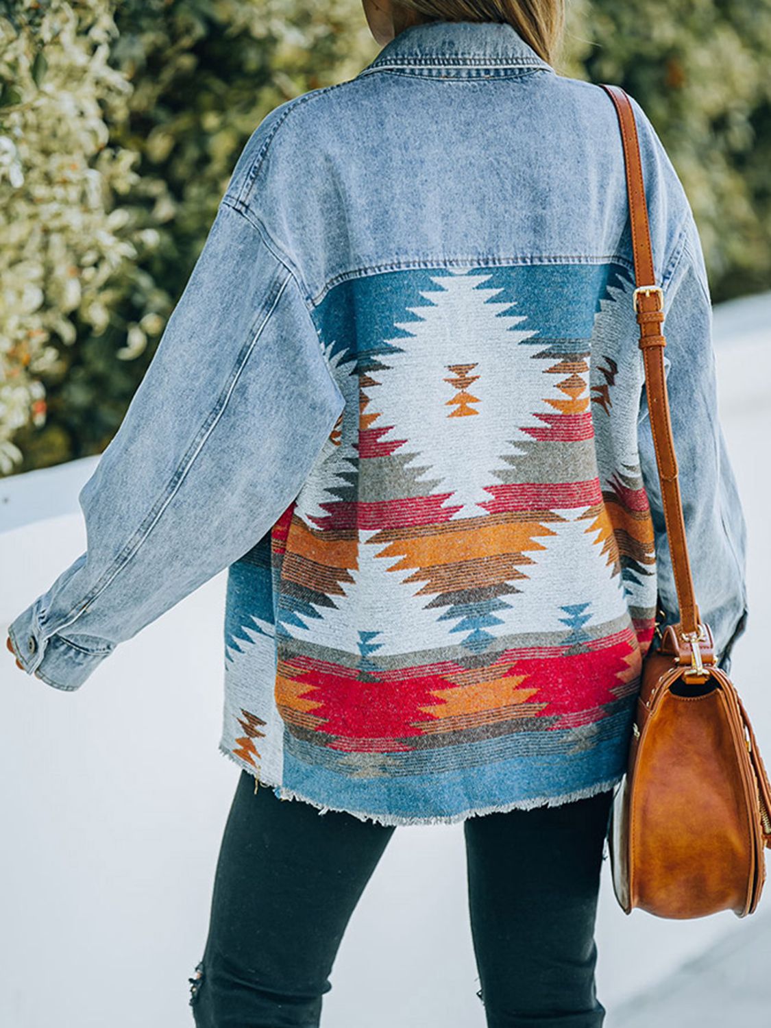  Woman in denim jacket with patterned fabric patches.