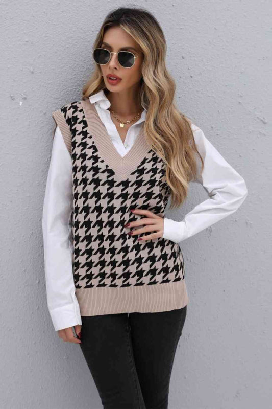 Woman standing in a beige houndstooth sweater vest and white button-down shirt, paired with black jeans, sunglasses, and a gold necklace.