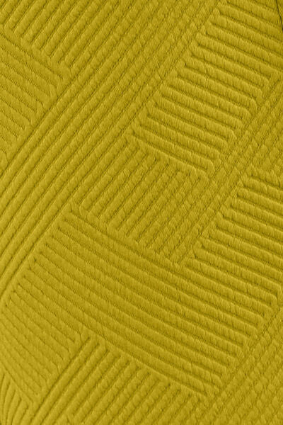 Textured yellow-green fabric with a geometric quilted pattern, displaying a complex array of stitched lines.